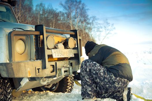 Land Rover Defender 110 suv and man tying tow rope. Car on background the Russian winter. February 19, 2011. Mattrazz Trophy # 18