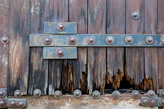 Lower part of an old heavy wooden door in ancient house 