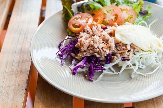 tuna with sliced cabbage salad on dish on wood table