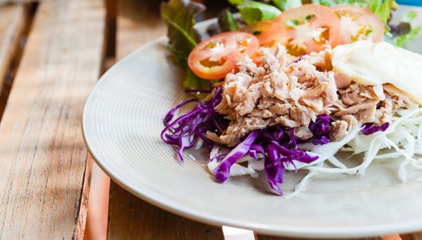 tuna with sliced cabbage salad on dish on wood table