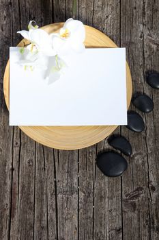 Conceptual image of Paper Bath Mats and stones spa on a wooden table