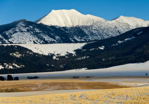 Sunlight Peak and farm fields in winter, Park County, Montana, USA