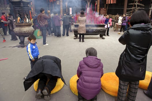 CHENGDU - FEB 5: People praying to Buddha in temple during chinese new year on Feb 5, 2011 in Chengdu, China.Many people want to relieve their worries and difficulties by burning incense and praying to Buddha during festivals.It's part of the important traditional custom in China.