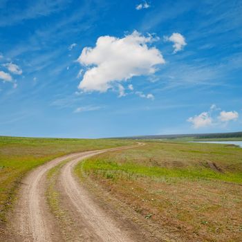 winding rural road to horizon under cloudy sky