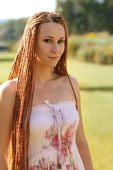 Beautiful girl with pigtails on in the park summer morning