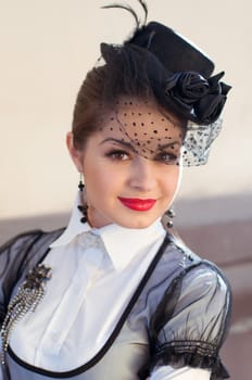 Portrait of a fresh and lovely woman wearing a hat with a veil and white blouse with a brooch on her breast