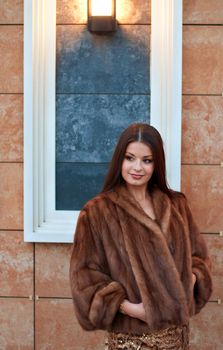 Portrait of luxurious young woman in a fur coat