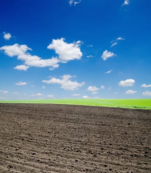 black ploughed field and cloudy sky