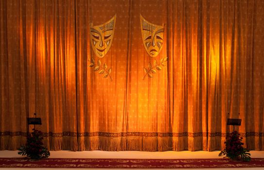 Theatrical masks on the curtains