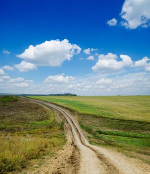 winding rural road under deep blue cloudy sky