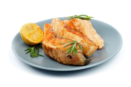 Three Slices of Grilled Salmon with Rosemary and Lemon closeup on Green Plate isolated on white background