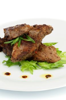 Three Slices of Delicious Roasted Beef with Spices and  Rosemary on White Plate with Lettuce closeup 