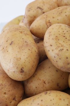 Closeup background of whole uncooked cleaned farm fresh potatoes conceptual of cooking ingredients or an agricultural crop