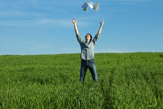 young man throwing a paper in the green field