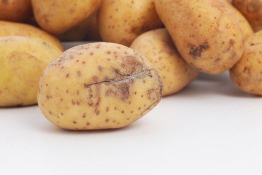 Fresh whole raw potato damaged during harvesting with a cut through the skin which is discolouring