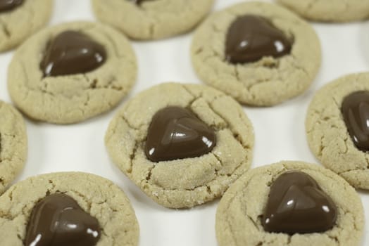 heart shaped chocolate on peanut butter cookies with a white background