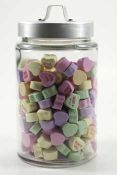 jar with lid filled with valentine hearts isolated on a white background