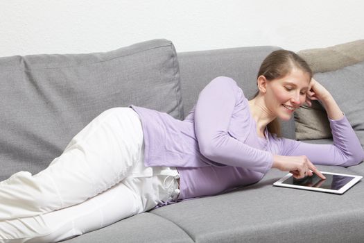 relaxing women using and tablet -pc at home