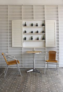 Table and chairs with white wood wall