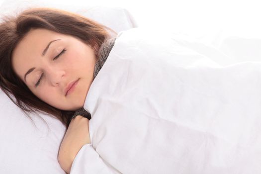 A young woman sleeping in her bed.