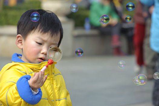 child blowing soap bubbles