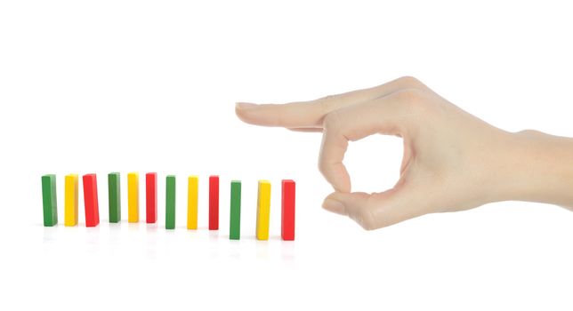 A human hand starts a domino game. All ioslated on white background.