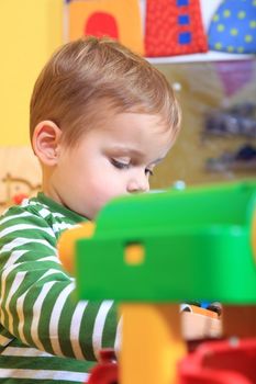 Cute caucasian toddler playing in kindergarten.