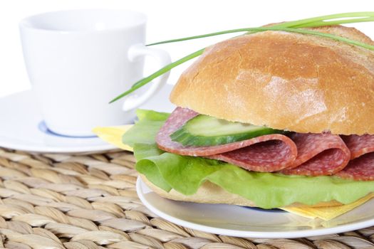 Fine served wheat roll with salami. All on white background.