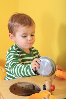 Cute caucasian toddler playing in kindergarten.