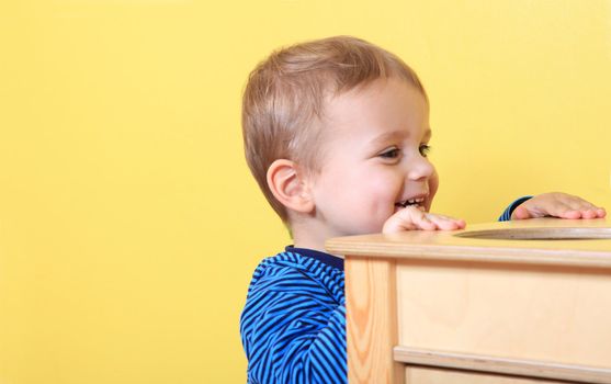 Cute european toddler having fun in kindergarten. Extra text space on left side.