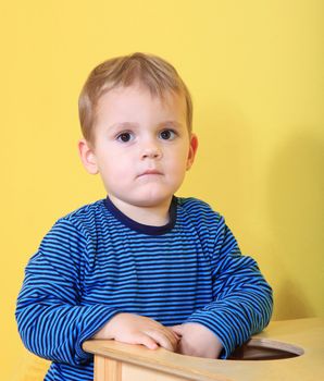 Cute caucasian toddler missing his mum in kindergarten.