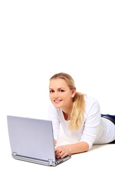 Attractive blond woman lying on floor using notebook computer. All on white background.