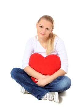 Attractive blond woman holding heart-shaped pillow. All on white background.