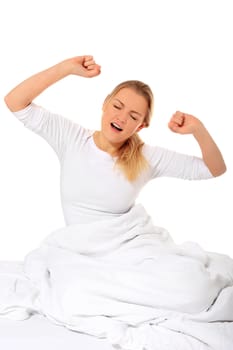 Attractive blond woman yawning in bed. All on white background.