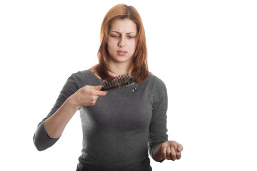 pretty girl with a sad look on the remaining hair on the comb on a white background isolated