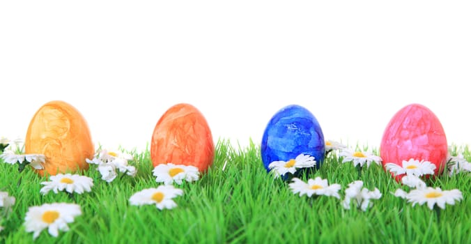 Colored easter eggs on green meadow. All on white background.