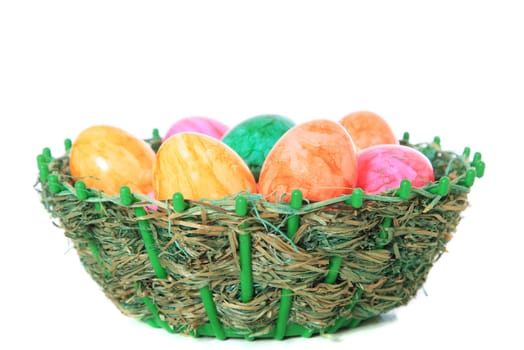 Colored easter eggs in a basket. All on white background.