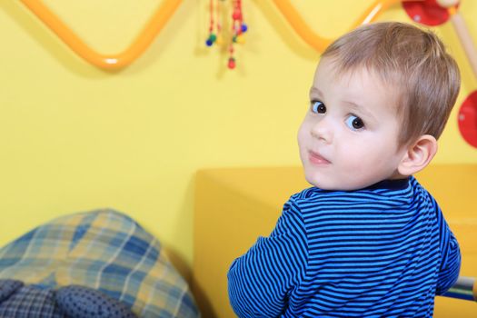 Cute european toddler having fun in kindergarten.