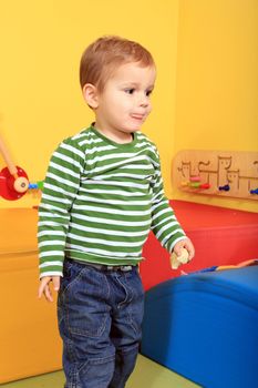 Cute european toddler having fun in kindergarten.