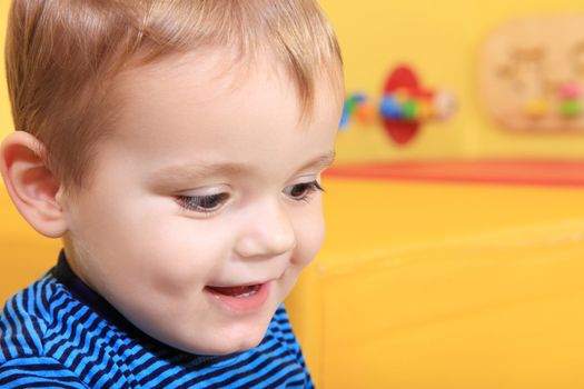 Cute caucasian toddler having fun in kindergarten.