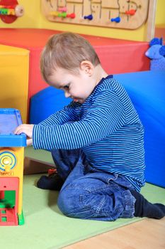 Cute caucasian toddler having fun in kindergarten.