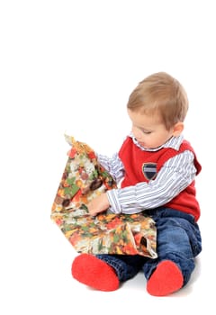Cute caucasian toddler unwrapping christmas gift. All isolated on white background.