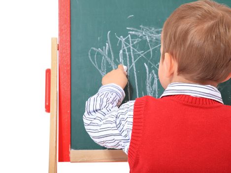 Cute caucasian toddler doodling on chalkboard. All isolated on white background.