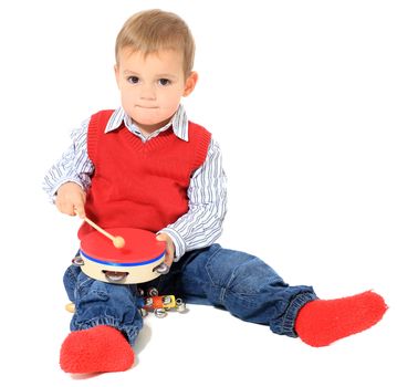 Cute caucasian toddler playing with music instruments. All isolated on white background.