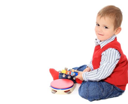 Cute caucasian toddler playing with music instruments. All isolated on white background. Extra copy space on left side.