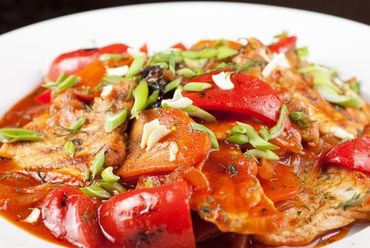 pork meat with tomato, pepper, prunes, garlic and green onion