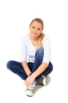 Attractive blond woman sitting on the floor. All on white background.