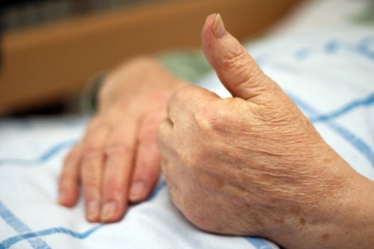 Care-dependent person showing thumbs up.