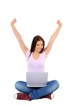 Attractive teenage girl sitting on the floor, cheering while using her notebook computer. All on white background.