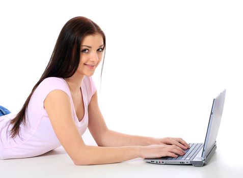 Attractive teenage girl lying on the floor using notebook computer. All on white background.